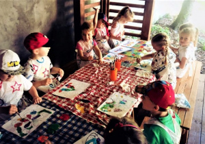 Dzieci w trakcie malowania farbami motyli